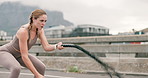 Woman, battle ropes and fitness or outdoor speed for workout performance, muscle or exercise. Female person, equipment and health training in urban city on road for hard work, progress or strength
