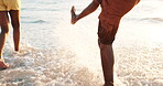 Legs, couple and water splash or playing at sunset, freedom and bonding in nature on weekend trip. People, closeup and having fun or love in ocean, romance and waves on vacation or summer holiday