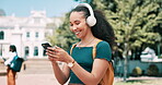 Woman, smartphone and typing outdoor with headphones, student on campus with communication and laughing. Chat, internet search and listening to music, social media with funny meme or college email