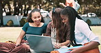 Laptop, education and student woman friends outdoor on college campus to study for exam or test together. Computer, learning or scholarship with group of young people on field of grass at university