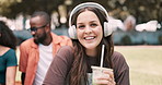 Students, woman in headphones and college campus for education, listening to e learning audio or music at park. Portrait, face or young person with smoothie drink for university or happy scholarship