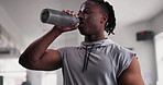 Fitness, bottle and black man drinking water at gym for exercise, break or intense performance recovery. Hydration, drink and athlete with sports liquid after training, exercise or workout challenge