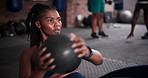 Black woman, medicine ball and exercise for workout, training or fitness on floor at gym. African female person in crunches for muscle, strength or endurance in practice for stamina at health club