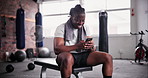 African man, phone and smile in gym for texting with meme, chat and web with sweat at training. Person, smartphone and happy with towel on app for exercise, workout or social media at fitness club