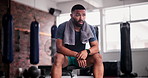 Gym, break and tired man with towel, break or breathing for  recovery from intense performance. Sports, burnout or male athlete sweating from physical challenge, workout or training, fatigue or rest