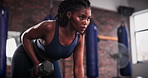 Black woman, dumbbell and weightlifting for exercise, strength or arm workout at gym. Serious African female person, athlete or bodybuilder in sports fitness, muscle gain or training at health club