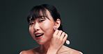 Beauty, funny and jade roller for face with asian woman in studio on dark background for skincare or wellness. Portrait, massage or laughing and happy young person with product for dermatology