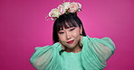 Flower crown, fashion and face of Asian woman with beauty, confidence and cosmetics on pink background. Spa, floral aesthetic and portrait of person with makeup, glow and organic products in studio