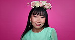 Face, beauty and Asian woman with flower crown in hair at studio isolated on a pink background. Portrait, wreath and floral cosmetics of natural Korean model in organic skin makeup, fashion or smile