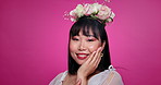 Pink background, skincare and face of Asian woman with flower crown for wellness, confidence and smile. Salon, floral aesthetic and portrait of person for natural beauty and cosmetics in studio