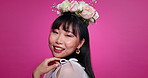 Flower crown, beauty and face of Japanese woman on pink background for wellness, confidence and skincare. Luxury salon, floral aesthetic and portrait of happy person for natural cosmetics in studio