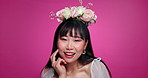 Pink background, cosmetics and face of Asian woman with flower crown for wellness, confidence and smile. Salon, floral aesthetic and portrait of person for natural beauty, skincare and glow in studio