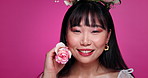 Beauty, fashion and portrait of Asian woman with flower, smile and creative makeup in studio. Happiness, plant and floral aesthetic for girl in Korea with rose, elegant style and pink background.