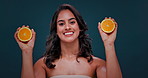 Skincare, orange and face of woman on blue background for wellness, facial treatment or cosmetics. Dermatology, spa and portrait of person with fruit for organic, natural vitamins and detox in studio