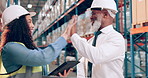 Warehouse, man and woman with a tablet, high five and conversation with planning and cooperation. Safety, manufacturing or manager with employee or tech with partnership or industry with digital app