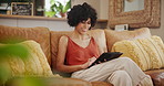 Happy woman, tablet and relax on sofa for social media, communication or networking at home. Female person sitting on living room couch, lounge or smile on technology for online chatting or research