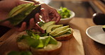 Hands, avocado and bread for sandwich, food and table for health, diet and wellness for breakfast in home. People, toast and prepare lettuce for nutrition, vegan meal and knife for bread in house