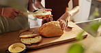 Couple, hands and cutting bread with butter, spread or roll for meal, snack or wheat in kitchen at home. Closeup of hungry people making food, morning breakfast or bun for healthy nutrition on table