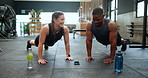 Happy people, fitness and push ups in team exercise or workout together on floor at gym. Interracial man and woman with smile for strength training, biceps and lifting body weight at health club