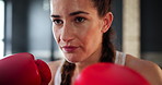 Woman, gym and boxing with training, sweating and practice for a match and endurance. Challenge, person or boxer with workout or fighter in a wellness centre or progress with energy, tired or sports