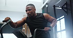 Fitness, spin class and black man in gym for training, intense workout and exercise for healthy body. Sports, cardio machine and person on cycling equipment for performance, muscles and wellness