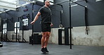 Fitness, power and man in gym skipping for workout, wellness and body building sport at club. Energy, training and athlete with jumping rope for muscle development, balance and action with challenge.