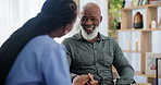 Conversation, nurse and senior man in living room of nursing home for medical consultation. Discussion, healthcare and caregiver talking to African elderly male patient in retirement at house.