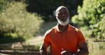 Grey bearded elderly man , runs with modern fitness tracker watch and in the morning next to beautiful greenery farm . Healthy senior old man jogging , improve body strength , doing fitness everyday
