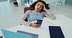 Laptop, phone and bored with business woman at desk in office with fatigue or exhaustion from work. Computer, burnout or social media distraction with app and frustrated young employee in workplace