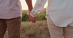 Back view, couple and holding hands outdoor in countryside, travel and holiday in Italy. People in relationship, adventure for bonding and time together in nature, wind and commitment with sunset