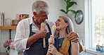 Couple, singing or laughing in kitchen, house or home while bonding and cooking lunch on holiday. Pensioners, joking and making food while wearing aprons on sunny, morning or afternoon in France