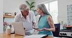 Laptop, argument and couple with document in kitchen for paying bills, mortgage or debt online. Fighting, stress and mature man and woman with paperwork and computer for internet payments at home.