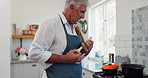 Funny, home and senior man cooking, hobby and healthy meal with fun and prepare dinner. Mature person, kitchen and pensioner with utensils and ingredients with singing and happy with a smile and joy