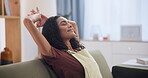 Woman, stretching and smile for relax in living room, wellness and lazy weekend on couch in apartment. Mexican lady, positive and break on sofa for calm rest, stress free and happiness in new home