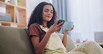 Woman, home and couch with coffee on smartphone, texting and social media browsing for post, news and updates. Apartment, living room and leisure with online  entertainment, interaction and fun.