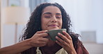 Woman, drink and coffee at home, sofa and relax after productive day at work with curly hair and smile. Female person, tea and enjoy from cup, couch and leisure time in house in lounge after campus