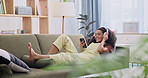 Headphones, phone and happy woman relax in home living room with technology, music or song. Smartphone, sound and smile of person on sofa listening to audio, radio or streaming playlist on mobile app