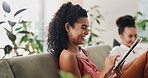 Woman, smile and tablet on sofa for social media, online shopping or networking in living room. Female person, laugh and technology on couch for website, search or communication from side view