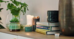 Table, closeup and books with candles, plants to relax for wellness, calm and zen for salon. Room, no people and stress relief for health, wealth and care for salon with balance and physical therapy
