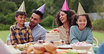 Children, parents and happy with hat at birthday party for celebration, laughing or memories in garden of home. Family, couple and kids with happiness for funny joke, gathering and event in backyard