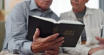 Couple, hands and home for reading bible, talking of faith and God with helping, support and scripture on sofa. Mature people or pastor in living room with holy book for religion and Christianity