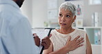 Patient, doctor and chest pain for consultation advice with clipboard for checklist or inflammation, Indigestion or infection. Female person, wellness and retirement or lung illness, healing or help