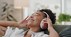 Happy woman, headphones and listening to music on sofa for podcast in living room at home. Calm young female person in relax or enjoying audio streaming, sound or song playlist with headset at house