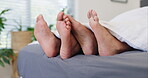 Couple, feet and bed or duvet play in apartment for morning relax or together for relationship, holiday or marriage. People, toes and barefoot touch with comfort in home or vacation, peace or bonding