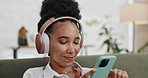 Home, headphones and woman with a cellphone, listening to sound and streaming music in a lounge. Person, apartment or girl with audio and headset with a smartphone and mobile user with radio or happy