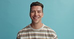 Man, face and smile in studio for fashion, laugh or excited with trendy style by blue background. Person, model or happy guy with t shirt, clothes or comic in portrait with expression for funny joke