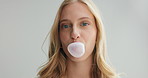 Woman, face and bubble with gum in studio for candy, closeup and headshot by white background. Girl, model or person with sweets in mouth with laugh for fresh breath with dental hygiene in portrait