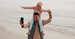 Smartphone, video and father with child at beach for bonding, vlog or social media post with piggyback. Happy, man and daughter by ocean with technology for vacation, holiday or memory together