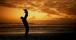 Father, child and lift in beach with silhouette, sunset and care with games with clouds in nature on holiday. Person, kid and bonding with love, waves and family at dusk for outdoor vacation with sky