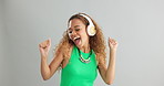 Excited woman, dancing and listening with headphones to music or sound on a gray studio background. Happy female person or model enjoying audio podcast, energy or vibe with headset on mockup space